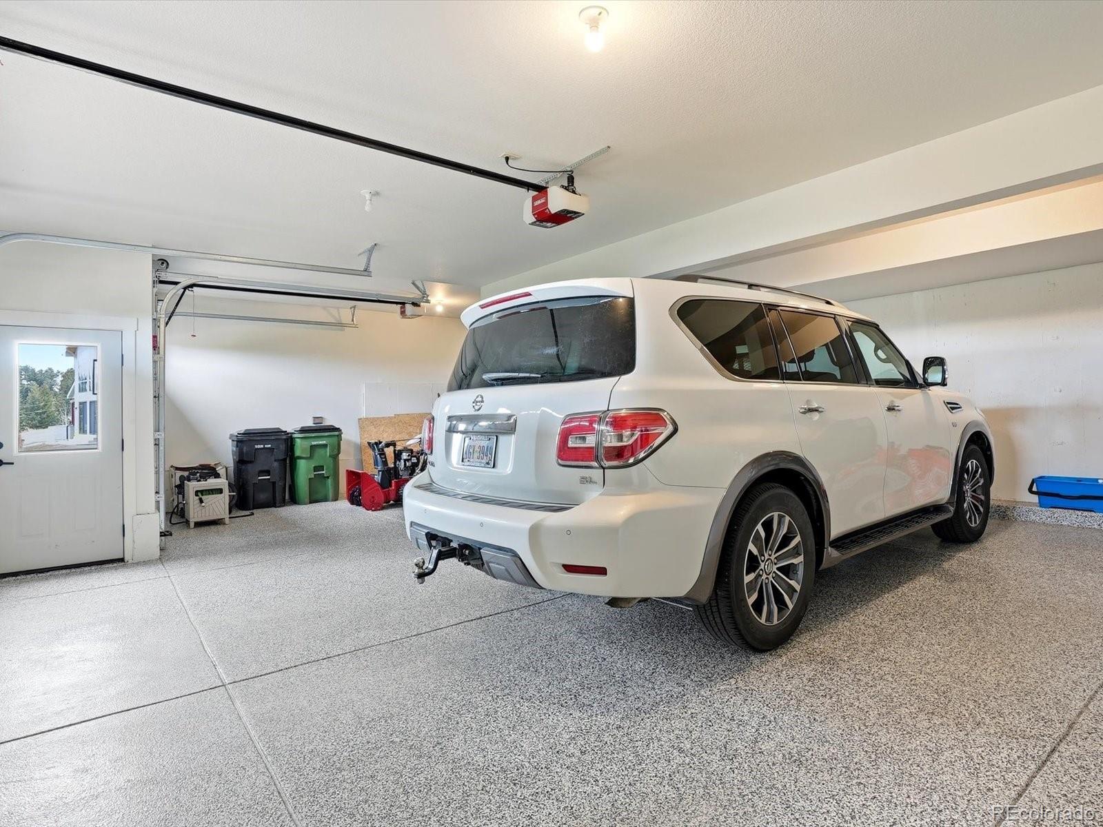 7333 Plowsher Way Morrison, CO 80465 - Photo 29 of 36 a car and bike parked in a garage