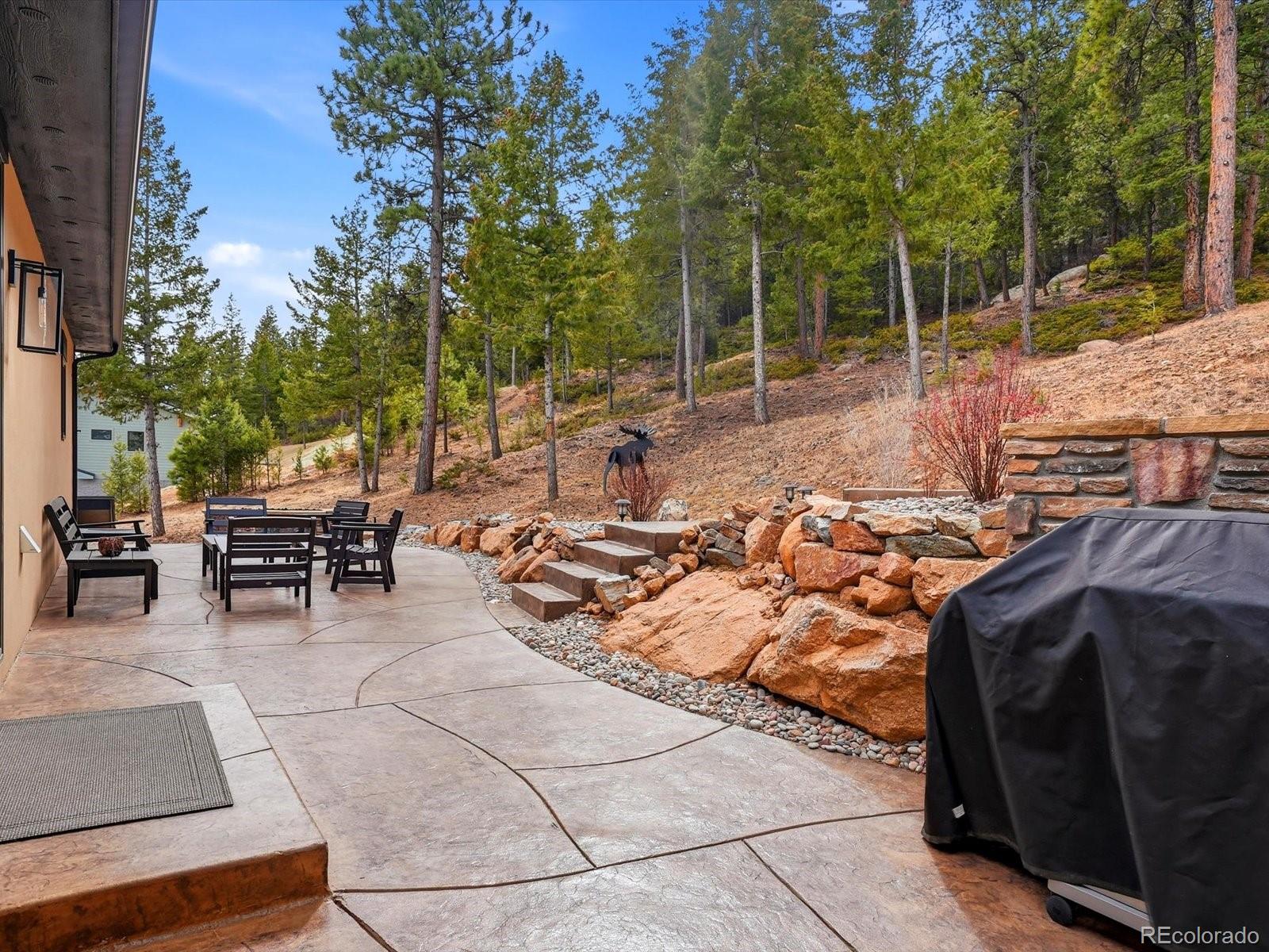 7333 Plowsher Way Morrison, CO 80465 - Photo 33 of 36 a view of a patio with table and chairs and potted plants