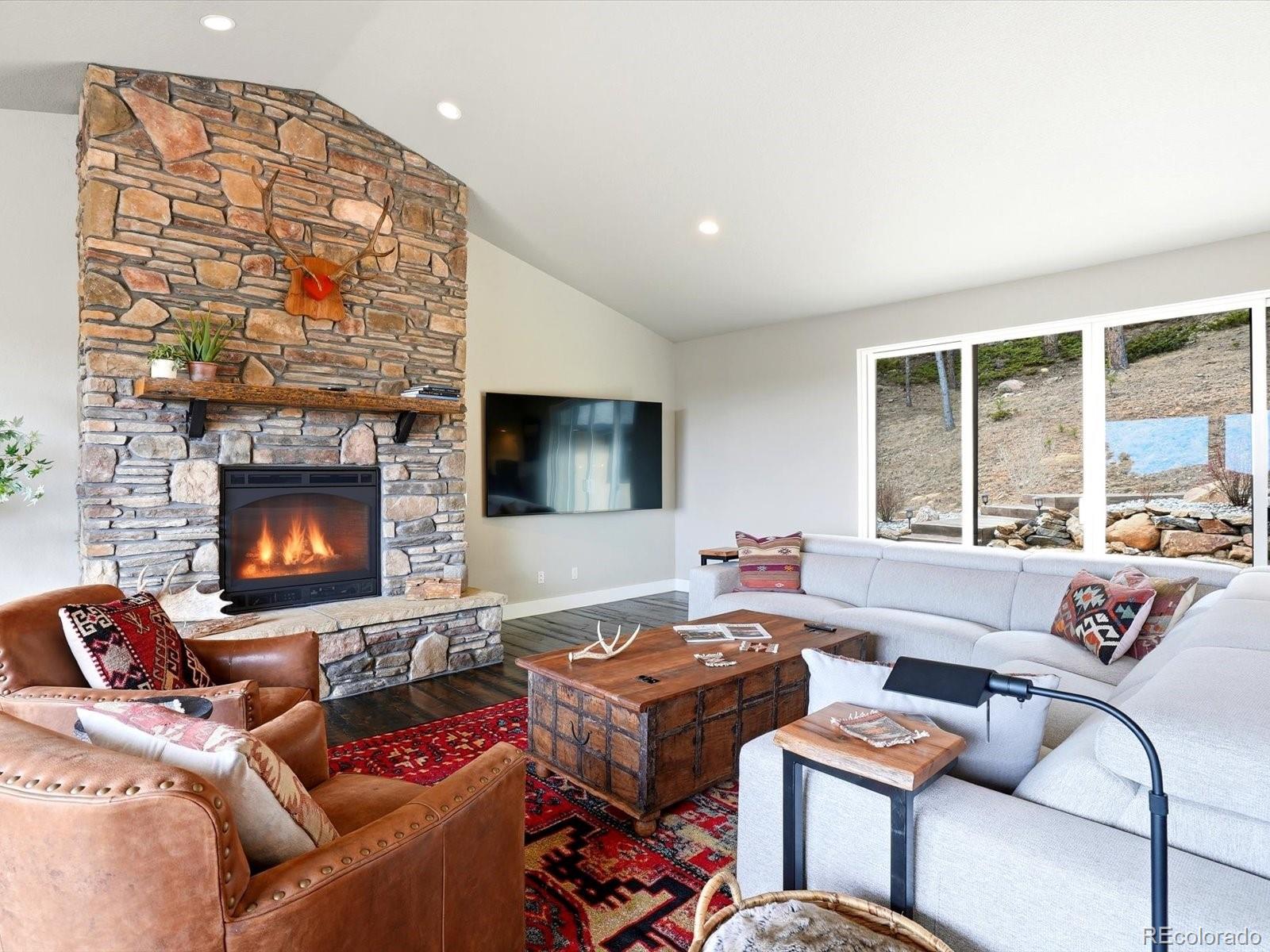 7333 Plowsher Way Morrison, CO 80465 - Photo 6 of 36 a living room with furniture and a fireplace
