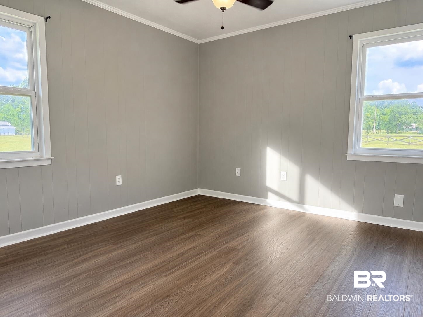11115 Appleton Road Castleberry, AL 36432 - Photo 9 of 18 Room featuring wood-finish flooring, neutral wall paneling, and white trim
