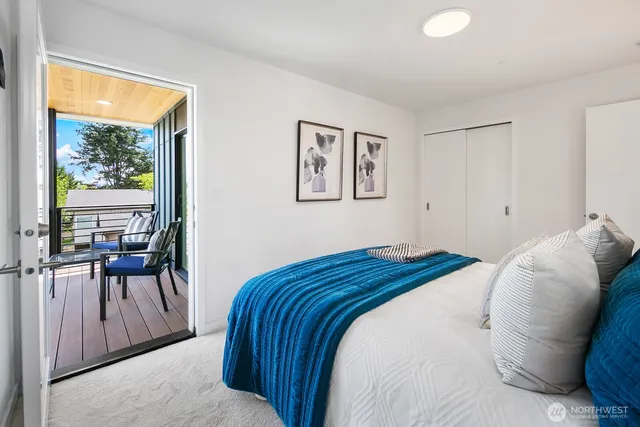 a bedroom with a bed and large windows