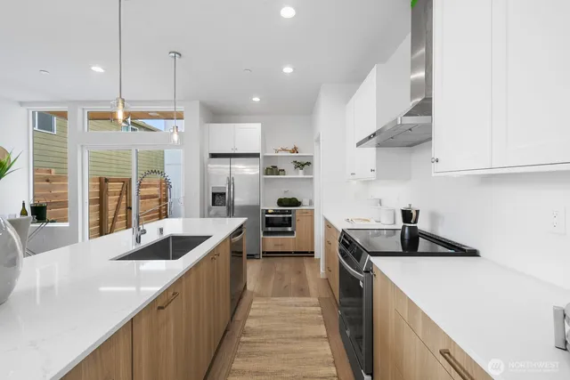 a kitchen with stainless steel appliances granite countertop a sink a stove and a refrigerator