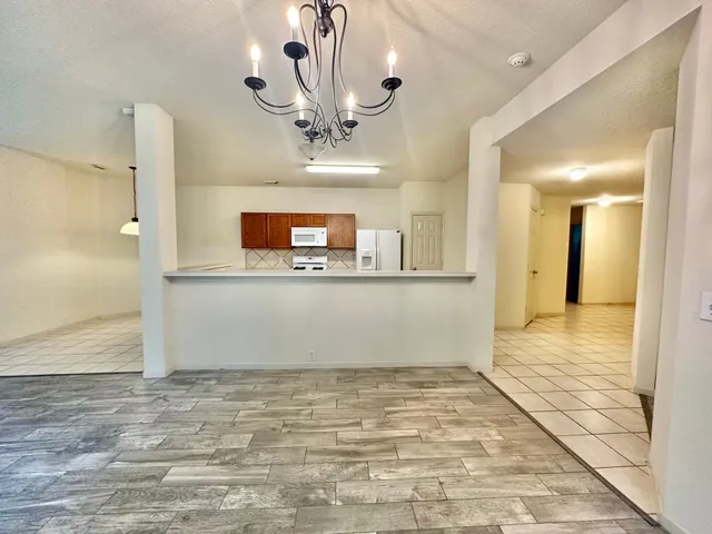 a view of a room with a fireplace and a chandelier fan