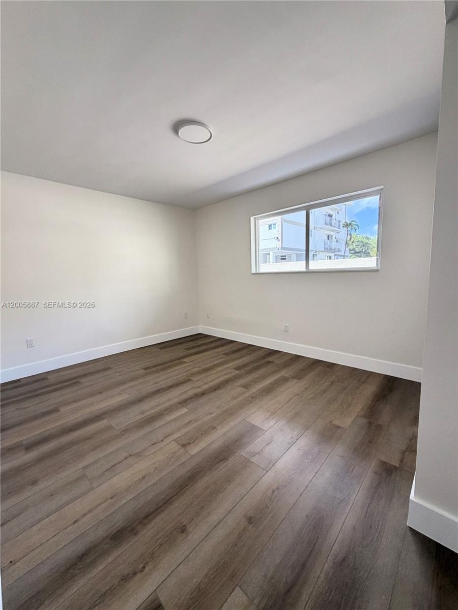 1904 Southwest 17th Avenue, Unit 8 Miami, FL 33145 - Photo 6 of 11 an empty room with wooden floor and windows
