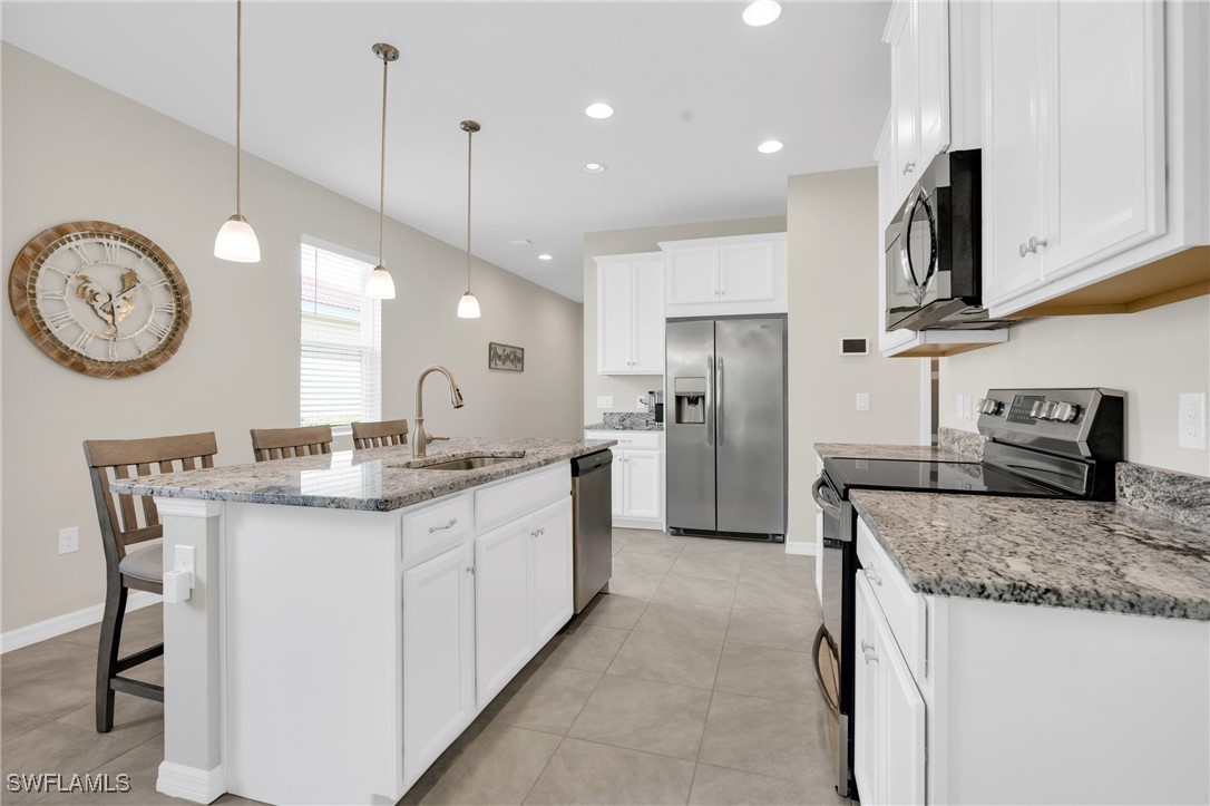 2125 Summersweet Drive Alva, FL 33920 - Photo 11 of 32 a kitchen with stainless steel appliances granite countertop a sink a stove and a refrigerator