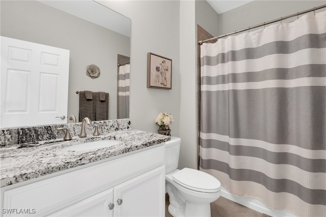 2125 Summersweet Drive Alva, FL 33920 - Photo 24 of 32 a bathroom with a granite countertop sink a toilet and a mirror