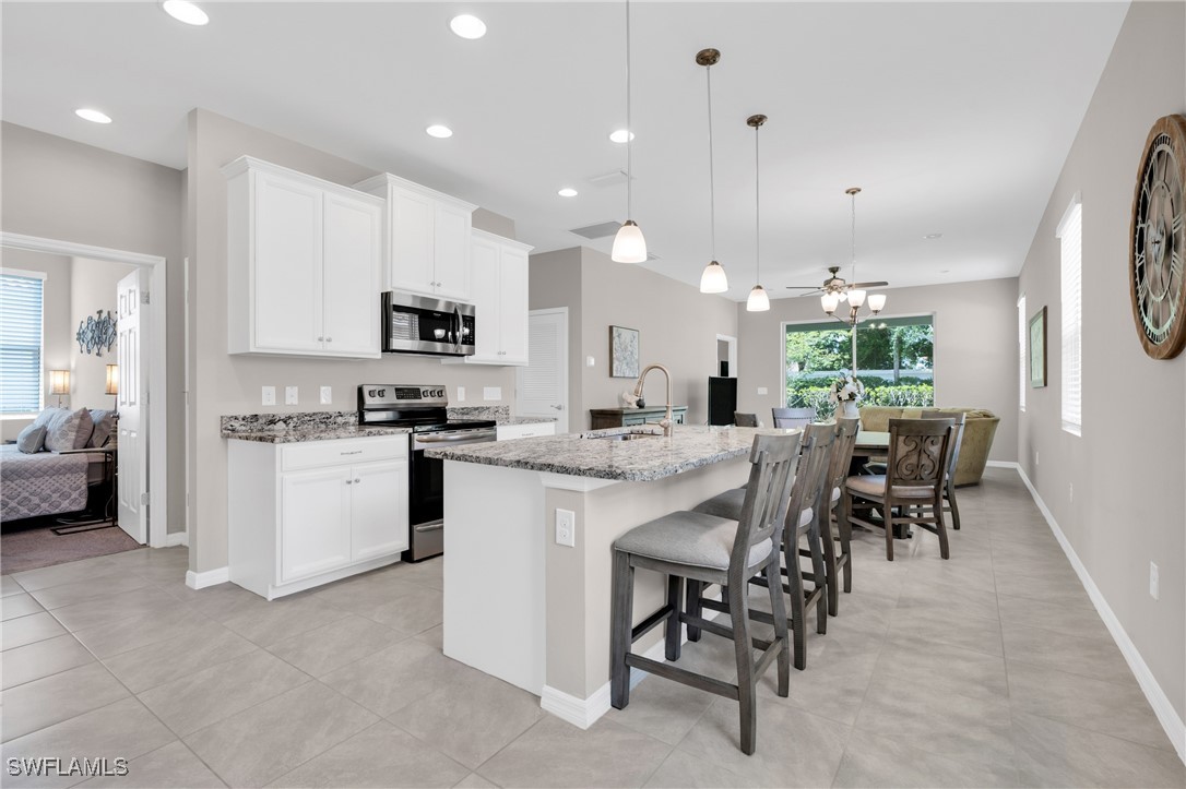 2125 Summersweet Drive Alva, FL 33920 - Photo 8 of 32 a kitchen with kitchen island granite countertop a stove a sink a dining table and chairs