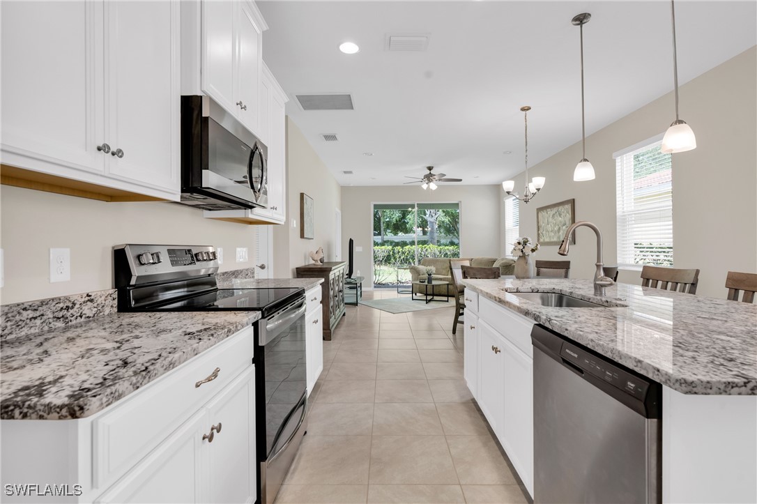 2125 Summersweet Drive Alva, FL 33920 - Photo 9 of 32 a kitchen with stainless steel appliances granite countertop a sink a stove top oven a counter space and cabinets