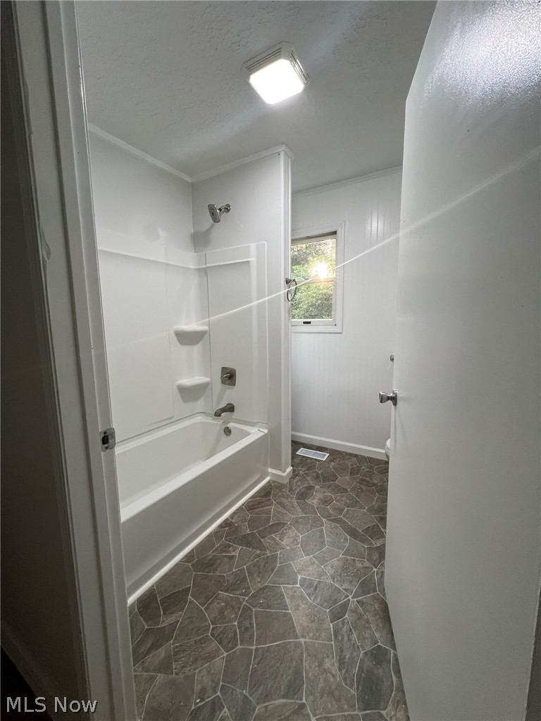 1105 Dutch Ridge Road Guysville, OH 45735 - Photo 14 of 33 Bathroom featuring a white tub-shower combination with built-in shelving, a single window, and geometric stone-pattern flooring