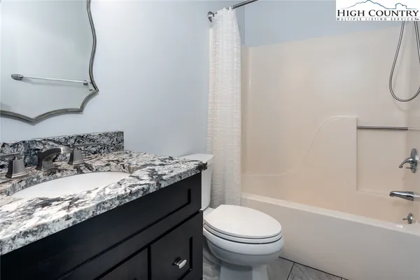 a bathroom with a granite countertop sink and a toilet