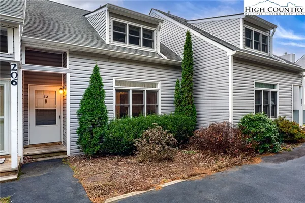 a view of a house with a yard and potted plants