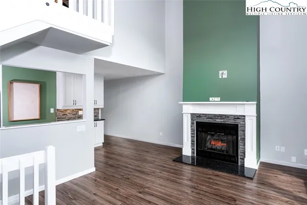 a view of a livingroom with wooden floor and a fireplace