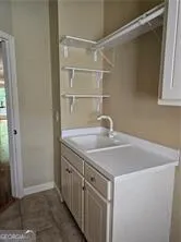 a room with a sink cabinets and a wooden floor