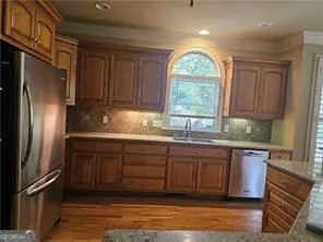 a kitchen with stainless steel appliances granite countertop a refrigerator sink and cabinets