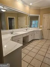 a spacious bathroom with a granite countertop sink and a mirror