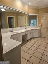 a spacious bathroom with a granite countertop sink and a mirror