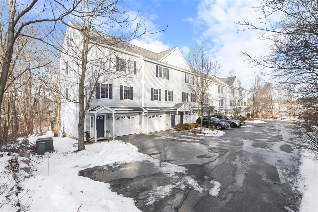 a view of a white house with a yard covered in snow