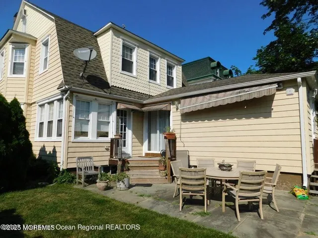 a view of a house with a yard and sitting area