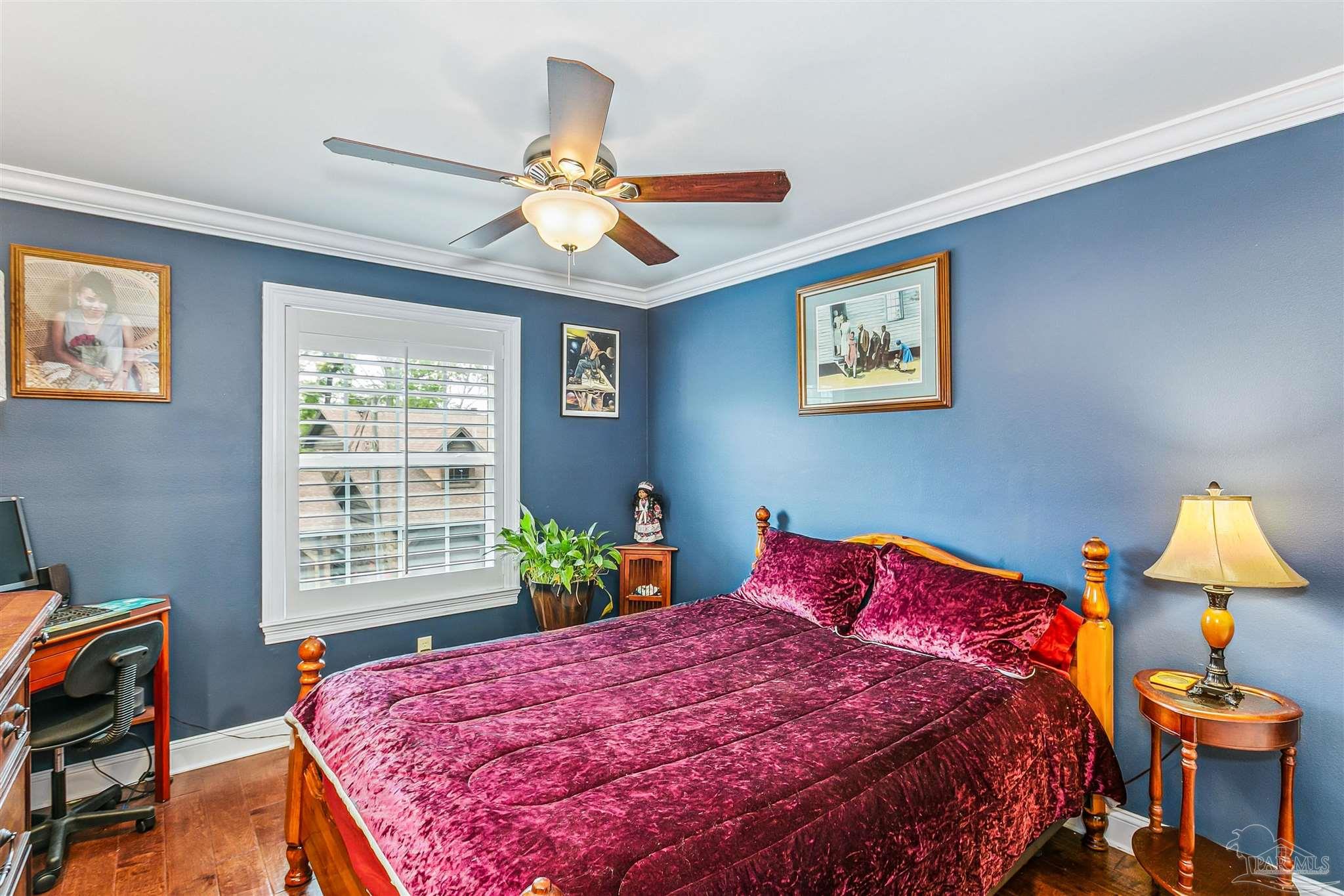 4831 East Olive Road, Unit 2D Pensacola, FL 32514 - Photo 21 of 29 a bedroom with a bed and a chandelier