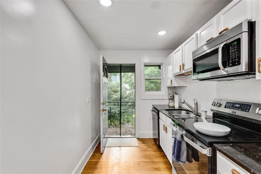 351 Cherokee Avenue Southeast, Unit 8 Atlanta, GA 30312 - Photo 9 of 28 a kitchen with stainless steel appliances a sink a stove a microwave and cabinets