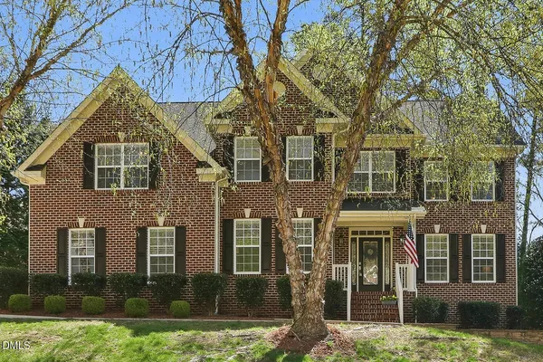 a view of a brick house with a large windows and a large tree