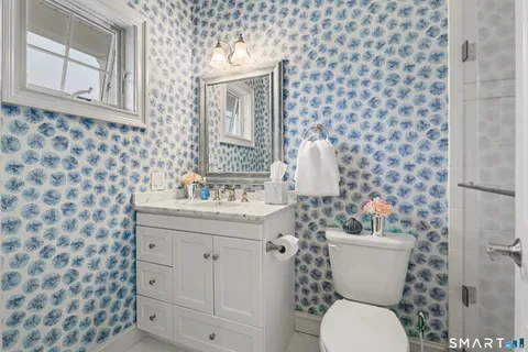 a bathroom with a toilet a sink and mirror