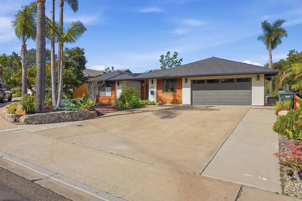 a front view of a house with a yard and potted plants