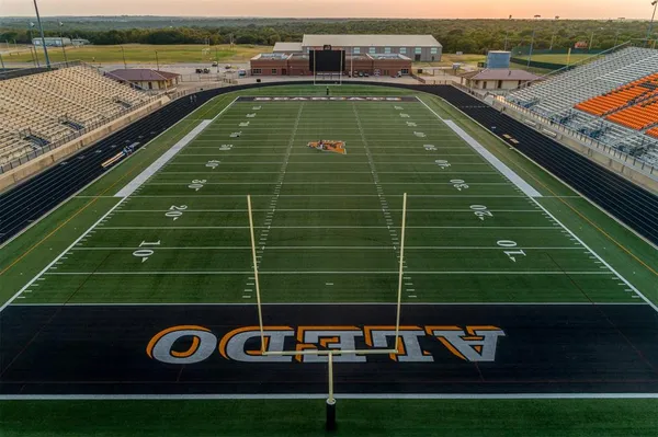 a kitchen with stainless steel appliances granite countertop a refrigerator a sink dishwasher a stove and white cabinets with wooden floor