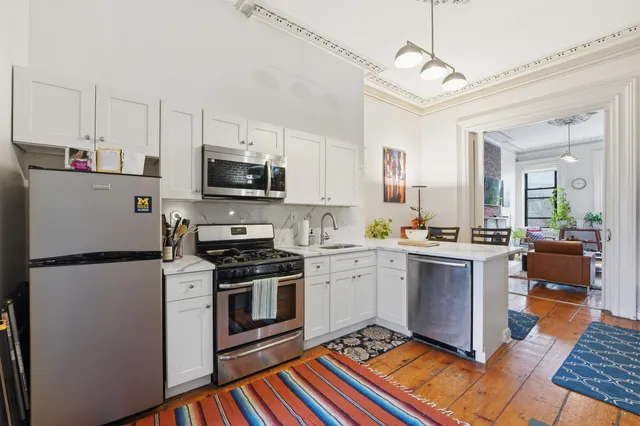 a kitchen with stainless steel appliances granite countertop a stove a sink and a refrigerator