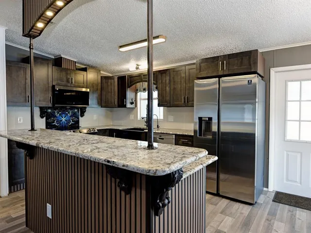 a kitchen with kitchen island a counter top space appliances and cabinets
