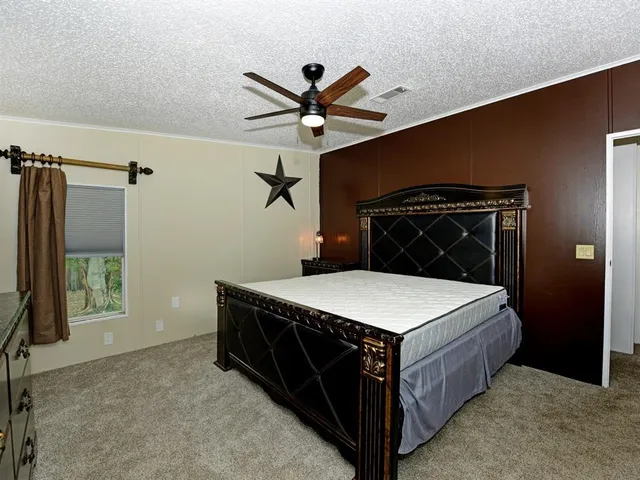 a bed room with a bed and a ceiling fan