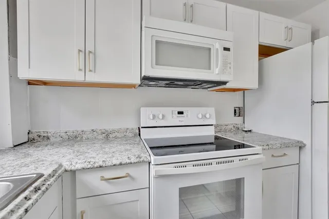 a kitchen with granite countertop cabinets stainless steel appliances and a sink