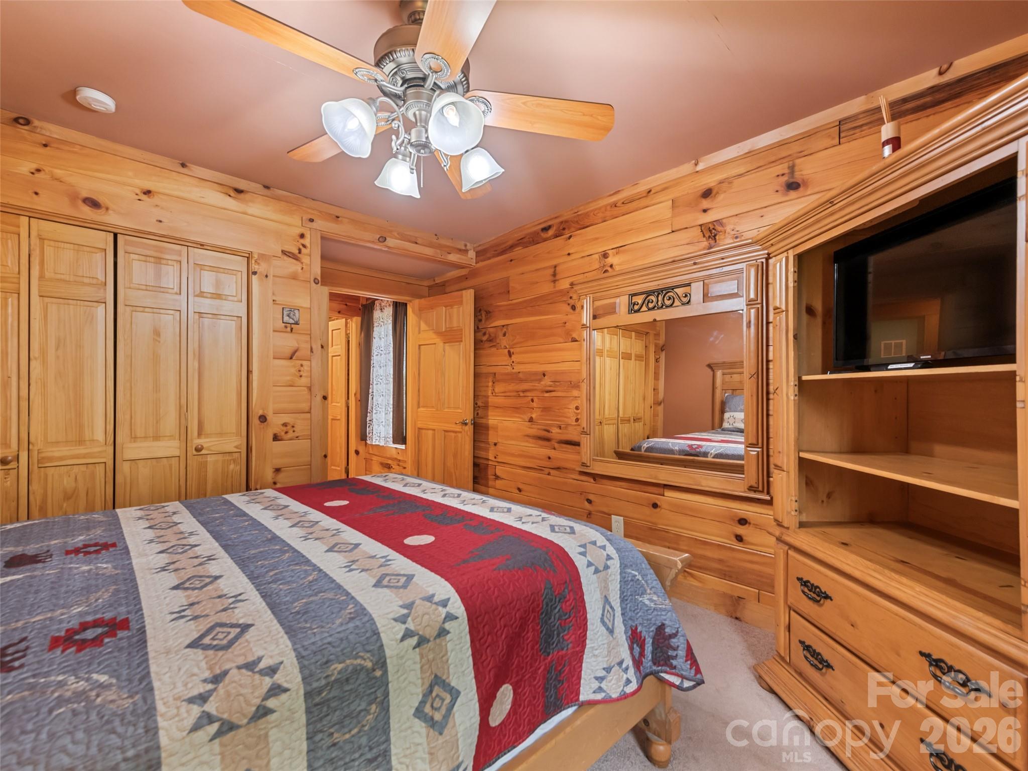 91 Copper Spur Road Maggie Valley, NC 28751 - Photo 12 of 29 a bedroom with a large bed and a chandelier