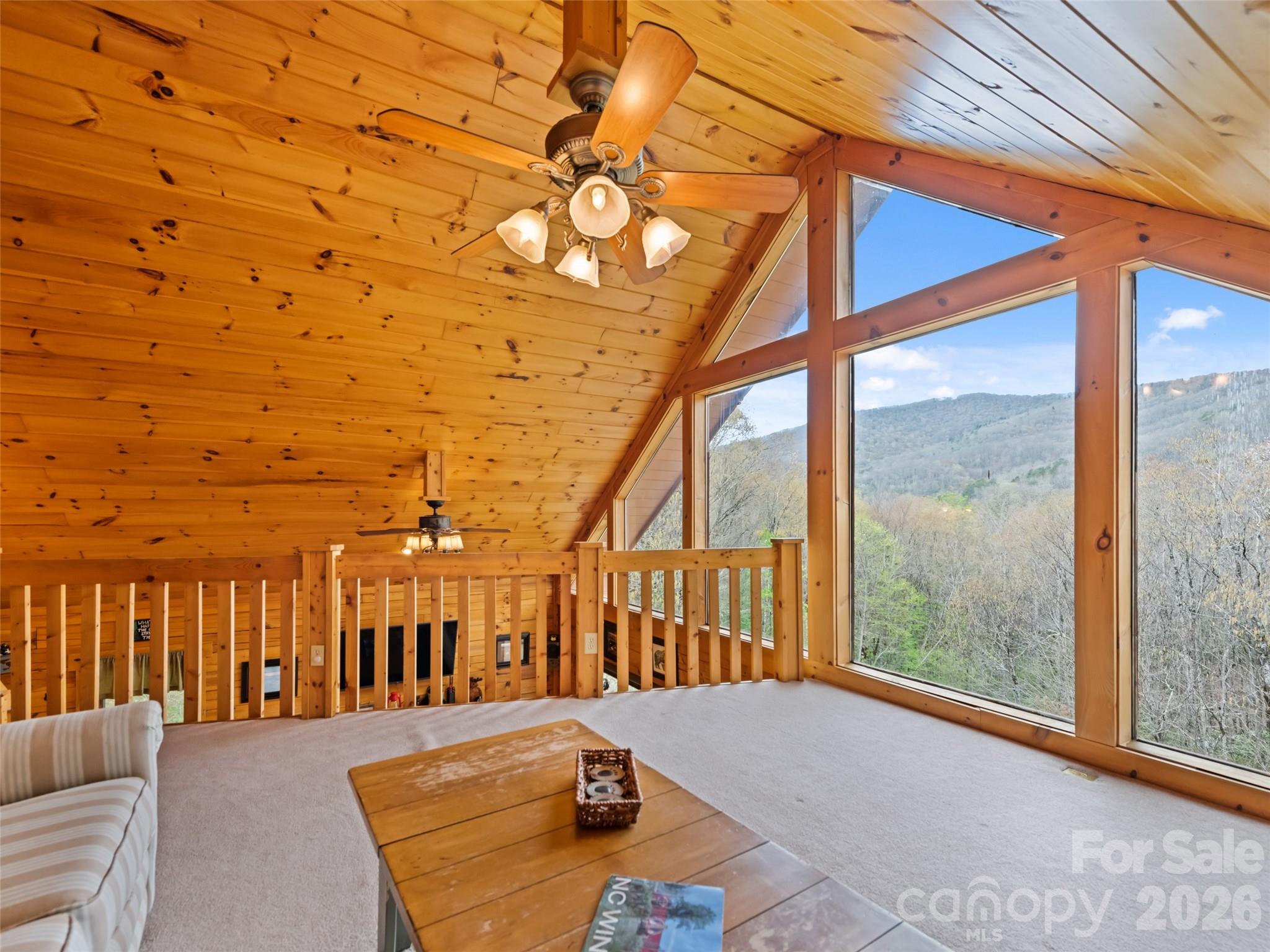 91 Copper Spur Road Maggie Valley, NC 28751 - Photo 15 of 29 a view of a balcony with couches and wooden floor