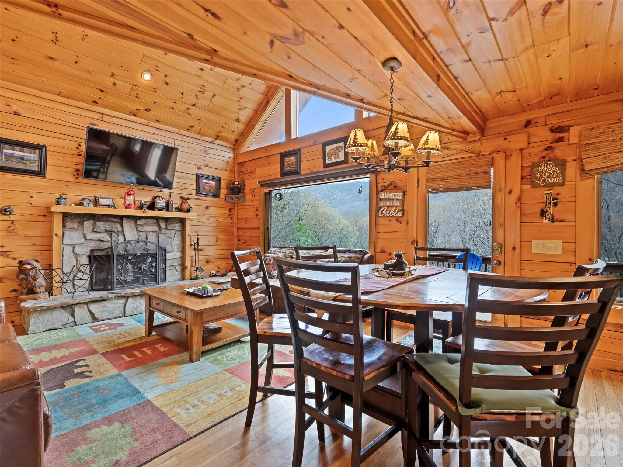 91 Copper Spur Road Maggie Valley, NC 28751 - Photo 4 of 29 a view of a patio with dining table and chairs with wooden floor