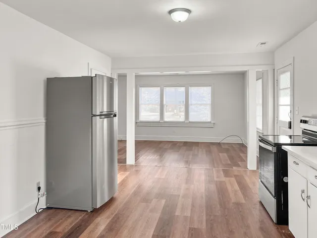 an empty room with wooden floor and a window