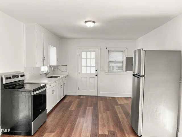 a kitchen with granite countertop a refrigerator stove and sink