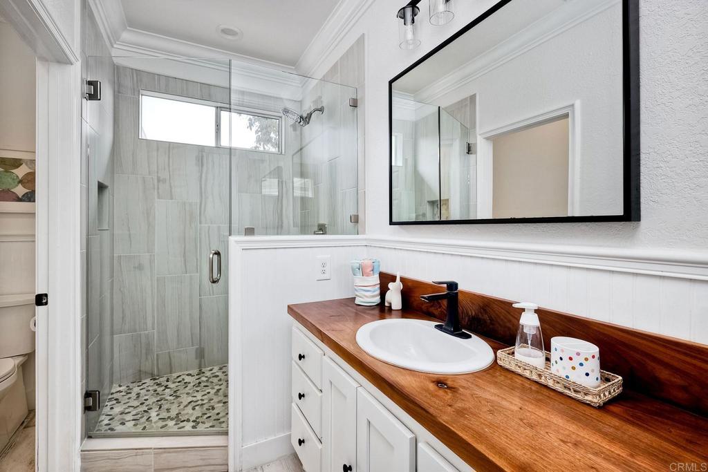 1054 Lighthouse Road Carlsbad, CA 92011 - Photo 27 of 44 a bathroom with a sink a mirror and a shower