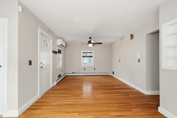 a view of a room with wooden floor and white walls