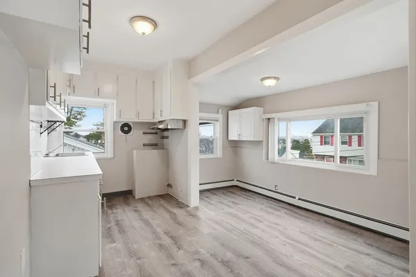 a view of empty room with wooden floor and window