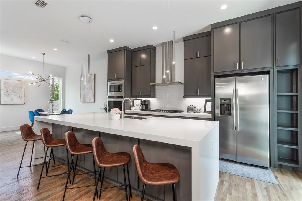 4425 Rusk Avenue Dallas, TX 75204 - Photo 4 of 19 a kitchen with stainless steel appliances granite countertop a sink a stove a refrigerator and island with wooden floor