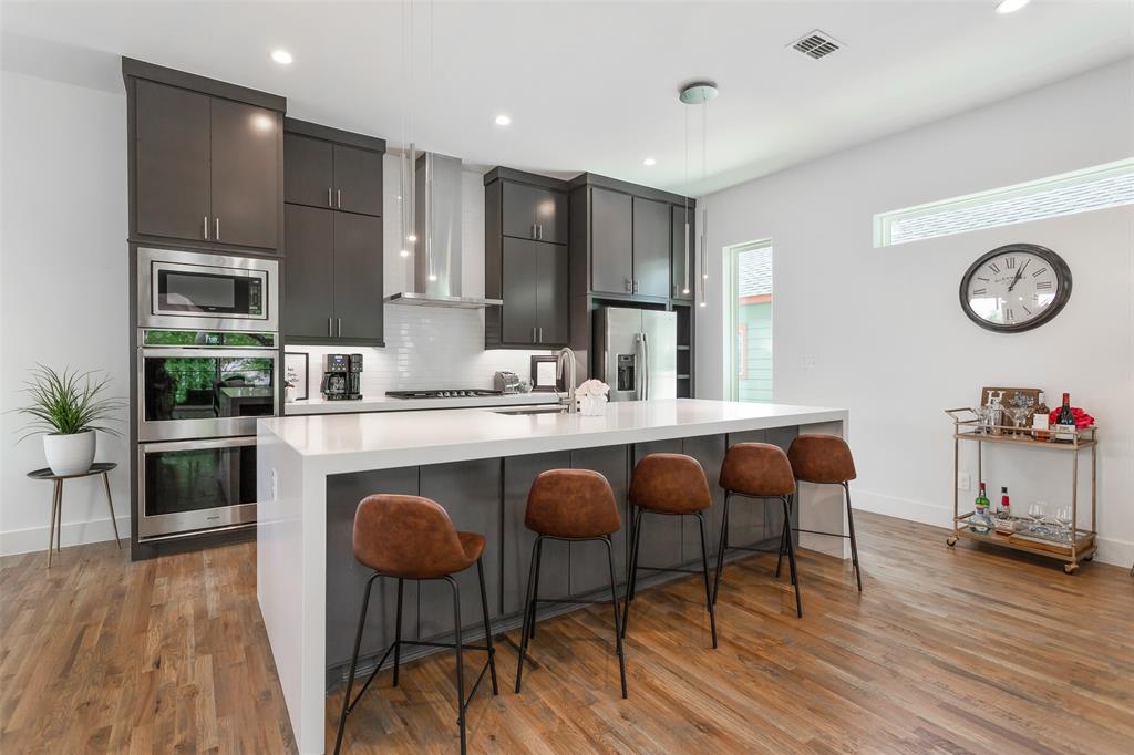 4425 Rusk Avenue Dallas, TX 75204 - Photo 5 of 19 a dinning room with stainless steel appliances granite countertop a kitchen island a stove a sink a refrigerator with a dining table and chairs