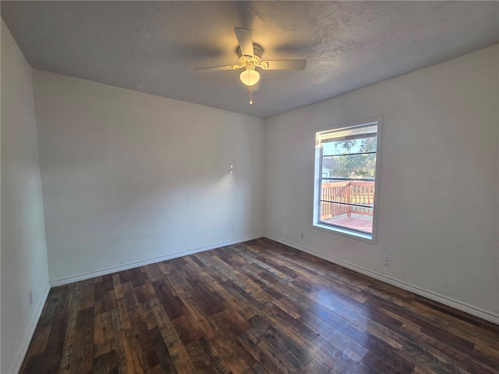 709 East Caesar Avenue Kingsville, TX 78363 - Photo 3 of 15 wooden floor in an empty room with a window