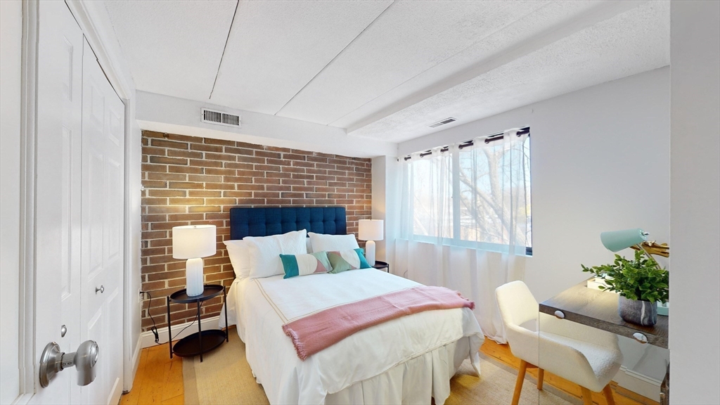 1856 Beacon Street, Unit 6F Brookline, MA 02445 - Photo 11 of 17 a bedroom with a bed and large windows