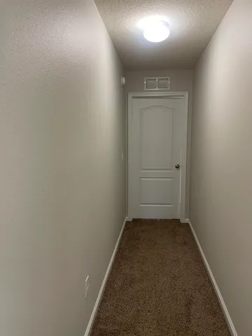 a view of a hallway with wooden floor and entryway