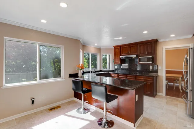a kitchen with stainless steel appliances granite countertop sink stove and microwave