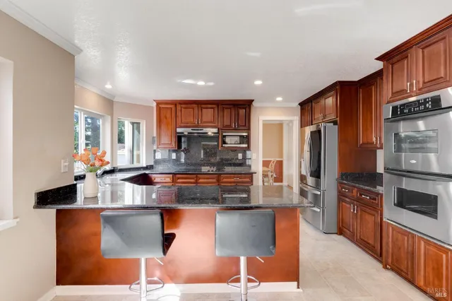 a kitchen with stainless steel appliances granite countertop a refrigerator and a stove top oven