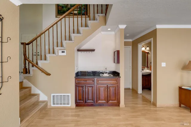 a view of a hallway with wooden floor and staircase