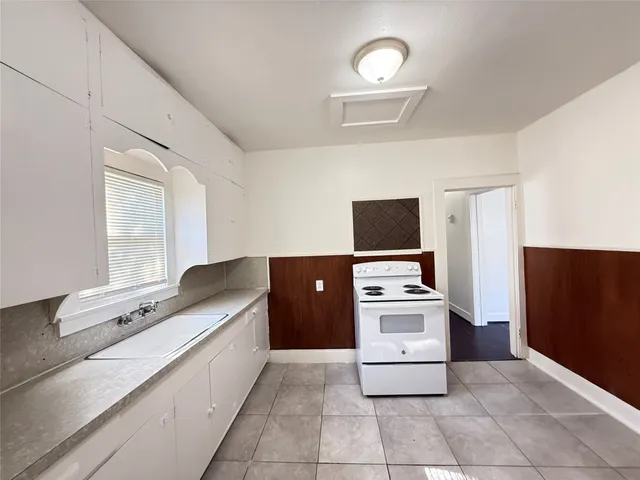 a kitchen with a stove top oven and cabinets