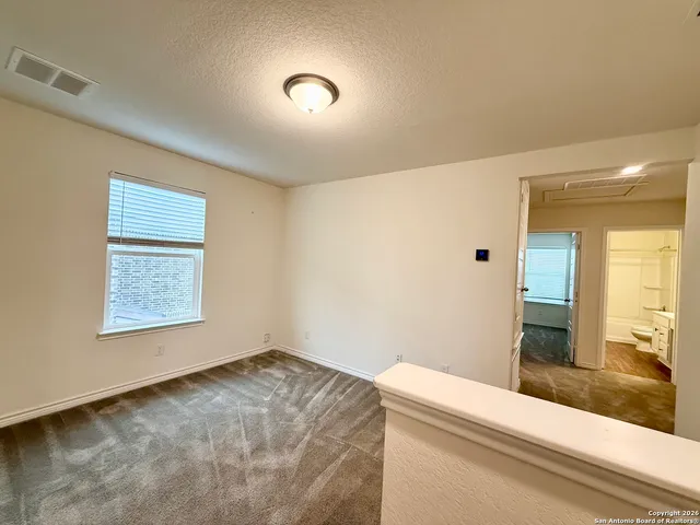 a view of an empty room with a chandelier fan